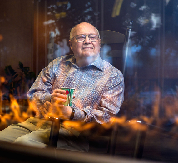 Blaine Garvin sits next to the Hemmingson fireplace.