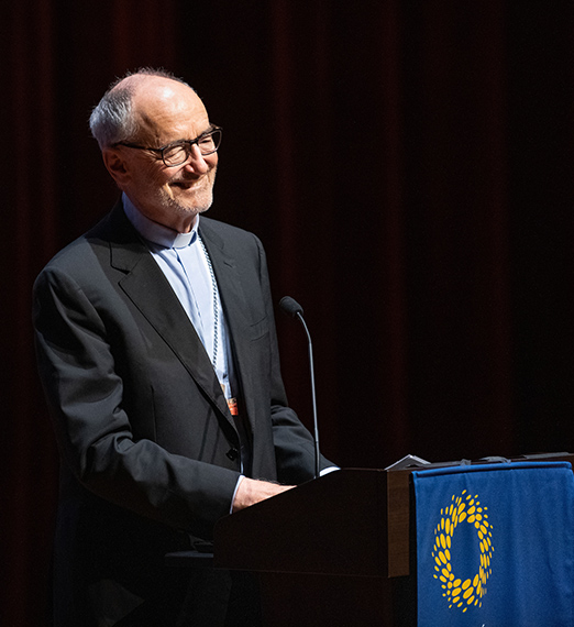 Cardinal Michael Czerny standing at a podium. 