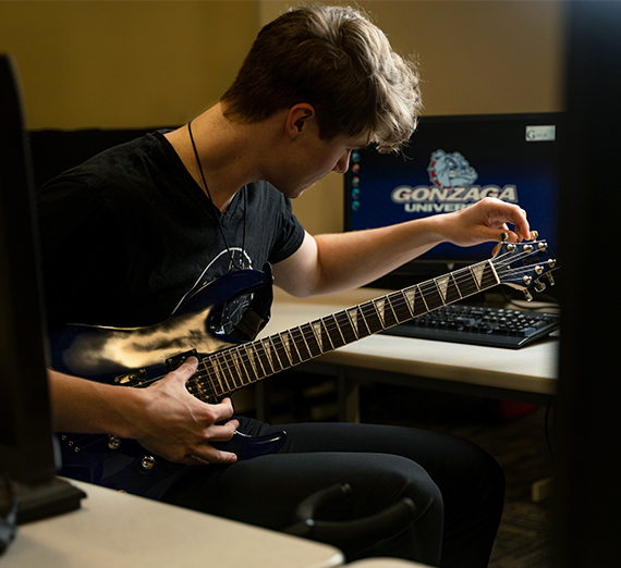 man tuning guitar